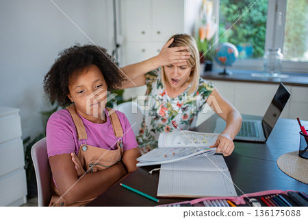Mom feeling stressed helping bored child with homework Mom feeling stressed helping bored child with homework 136175088
