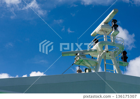 Navigation radar and communication antennas on ship bridge against clear blue sky background. Navigation radar and communication antennas on ship bridge against clear blue sky background. 136175307