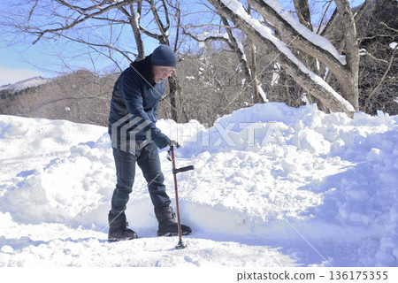 An elderly man doing rehabilitation using a walking stick on a snowy road An elderly man doing rehabilitation using a walking stick on a snowy road 136175355