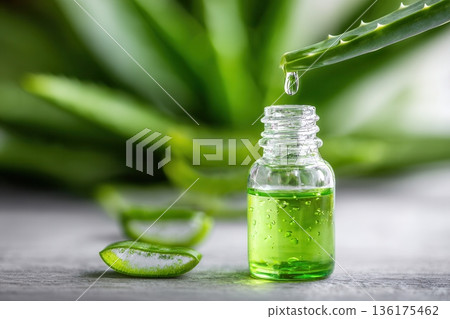 Aloe vera gel dripping into glass bottle Aloe vera gel dripping into glass bottle 136175462