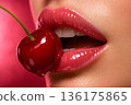 Red Cherry Between Glossy Female Lips Close Up 136175865