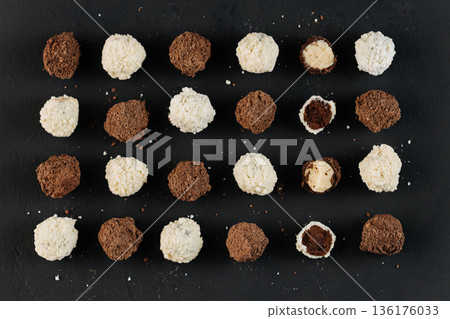 Assorted coconut and cocoa truffles on black slate, flat lay 136176033