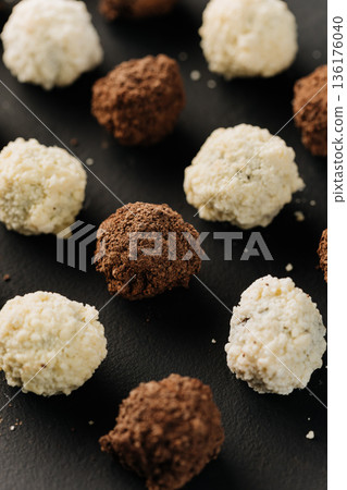 Close up of coconut and cocoa truffles on black background 136176040