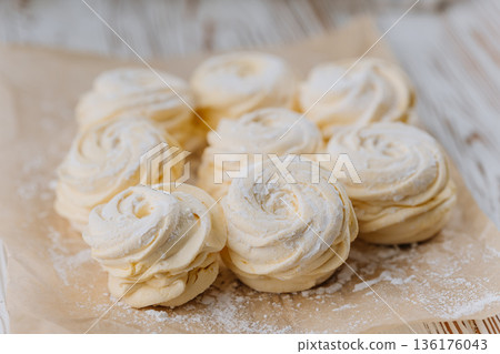Vanilla marshmallow swirl treats on parchment paper, closeup 136176043