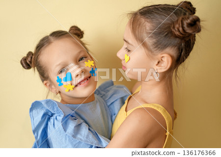 Two children together with puzzle and heart symbols on faces, concept of social equality, inclusion and support for people with Down syndrome, awareness, acceptance, diversity and empathy in society. Two children together with puzzle and heart symbols on faces, concept of social equality, inclusion and support for people with Down syndrome, awareness, acceptance, diversity and empathy in society. 136176366