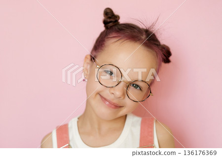 Portrait of a child wearing eyeglasses symbolizing vision care, eye health and eyesight correction. Concept of ophthalmology, children vision protection and medical prevention. Portrait of a child wearing eyeglasses symbolizing vision care, eye health and eyesight correction. Concept of ophthalmology, children vision protection and medical prevention. 136176369