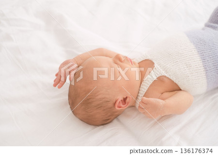Peaceful sleeping newborn baby lying on soft white bed. Concept of healthy infant sleep, early development, care, calmness, recovery, premature baby support, child wellbeing 136176374