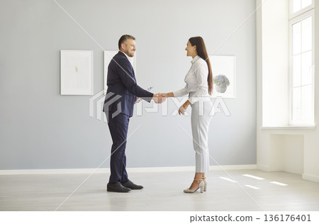 Real Estate Agent Shaking Hands With Client After Home Purchase Or Rental Deal 136176401