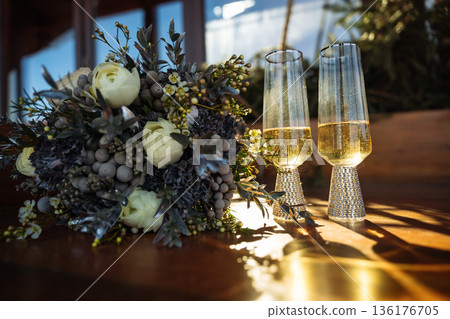 Wedding bouquet and champagne glasses with golden light 136176705