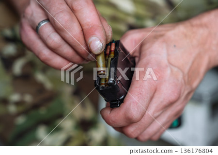 Loading rifle magazine with ammunition close up 136176804
