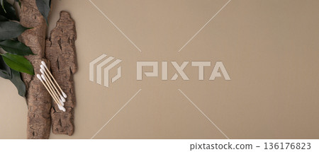 Wood cotton swabs on natural bark, green leaves Wood cotton swabs on natural bark, green leaves 136176823