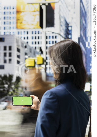 Horizontal mockup on smartphone near busy multicultural crowd moving along metropolitan crosswalk showcasing dynamic urbanism and everyday motion of modern downtown culture. Horizontal mockup on smartphone near busy multicultural crowd moving along metropolitan crosswalk showcasing dynamic urbanism and everyday motion of modern downtown culture. 136177066