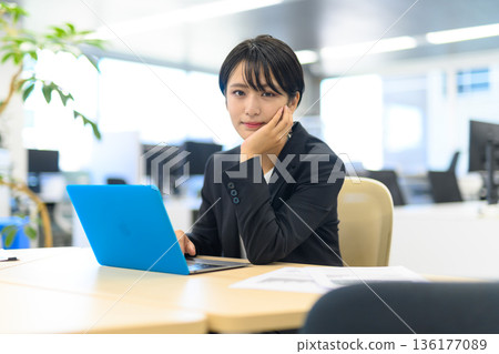 A woman is taking a break at her PC 136177089