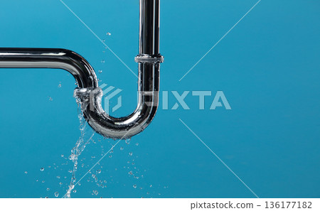 Leaking water from chromium stainless steel pipe under sink. Drain leak water from pipe plumbing in bathroom as water clogged drop. Blue bathroom background isolated Leaking water from chromium stainless steel pipe under sink. Drain leak water from pipe plumbing in bathroom as water clogged drop. Blue bathroom background isolated 136177182