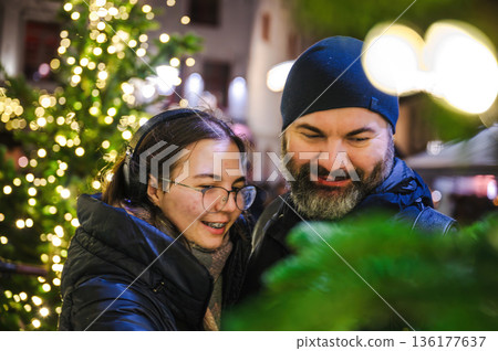 Cheerful Christmas Girl with Her Father and Festive Lights Cheerful Christmas Girl with Her Father and Festive Lights 136177637