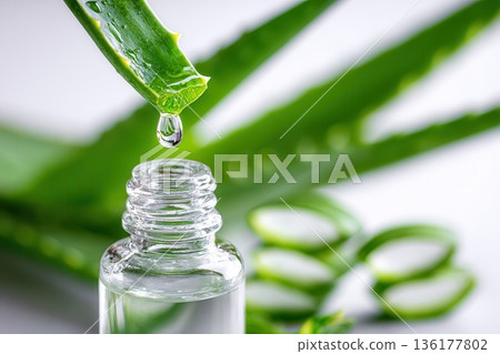 Aloe vera gel dripping into glass bottle Aloe vera gel dripping into glass bottle 136177802