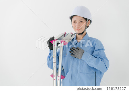 A woman in work clothes wearing a helmet 136178227