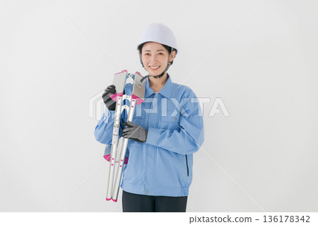 一名身穿工作服、頭戴頭盔的女子 一名身穿工作服、頭戴頭盔的女子 136178342