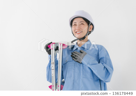 一名身穿工作服、頭戴頭盔的女子 一名身穿工作服、頭戴頭盔的女子 136178449