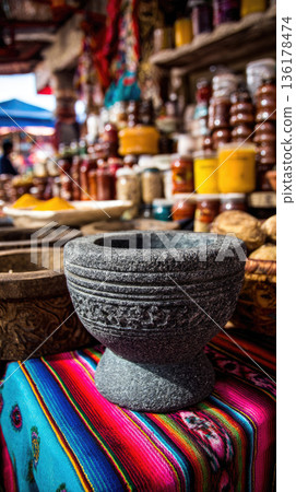 Mexican molcajete bowl sits on colorful textile in vibrant market surrounded by spices jars and traditional crafts creating authentic cultural atmosphere 136178474