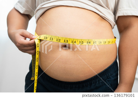 Asian woman with fat belly big size overweight and obesity with measure tape. 136179101