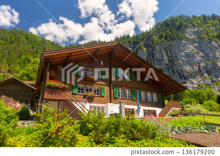 Traditional Swiss chalet with green shutters in alpine village Traditional Swiss chalet with green shutters in alpine village 136179200