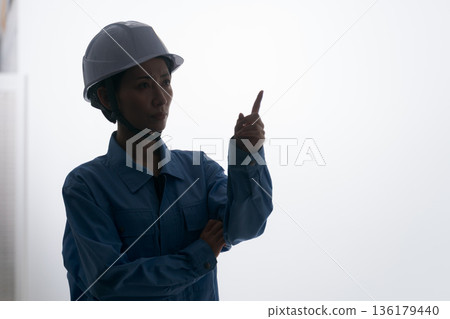一名身穿工作服、頭戴頭盔的女子 一名身穿工作服、頭戴頭盔的女子 136179440