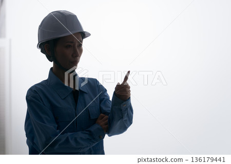一名身穿工作服、頭戴頭盔的女子 一名身穿工作服、頭戴頭盔的女子 136179441