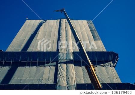 Cranes and blue sky of a building under construction b-3 Warm and cool colors Cranes and blue sky of a building under construction b-3 Warm and cool colors 136179493