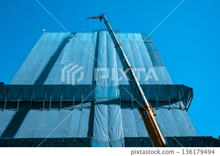 Cranes and blue sky of a building under construction b-4 light color 136179494