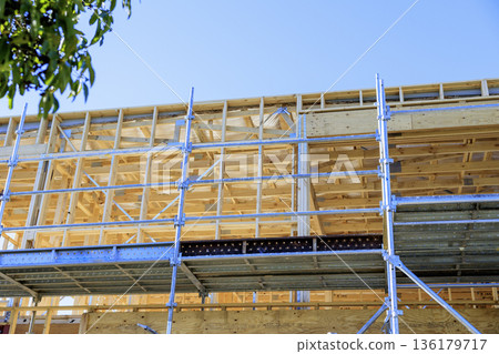 Construction site of a wooden house with scaffolding 136179717