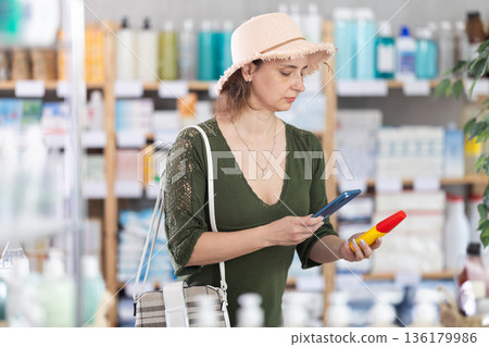 Adult woman paying for repellent spray by qr Adult woman paying for repellent spray by qr 136179986