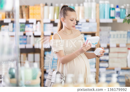 Pregnant young woman are busy choosing tablet box at pharmacy Pregnant young woman are busy choosing tablet box at pharmacy 136179992