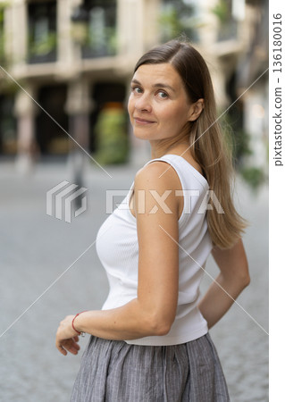 Female pedestrian in summer European capital, person in city 136180016