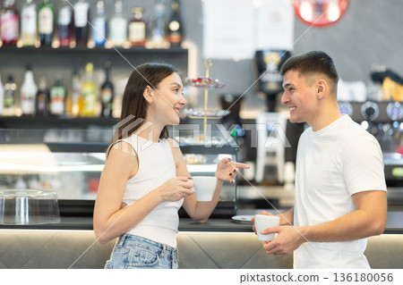 Young couple standing near counter in cafe 136180056