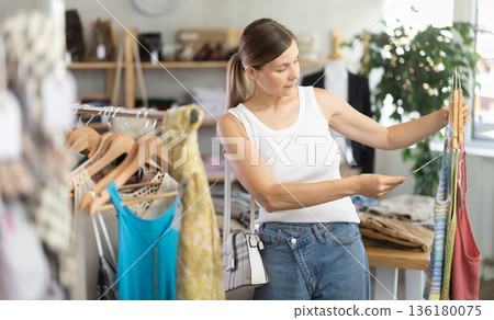Adult woman choosing summer clothes in store 136180075