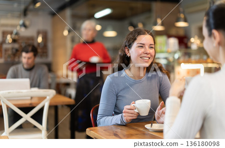 Two women talking over cup of coffee in cafe Two women talking over cup of coffee in cafe 136180098