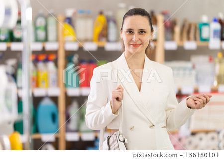 Adult woman chooses household chemicals in store Adult woman chooses household chemicals in store 136180101
