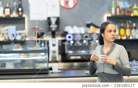 Young female cafe patron client drink coffee at bar counter 136180127