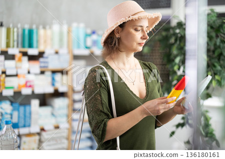 Woman buyer select sunscreen cream Woman buyer select sunscreen cream 136180161