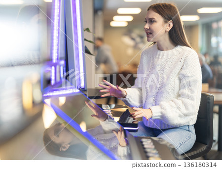 Girl is playing slot machines in casino Girl is playing slot machines in casino 136180314