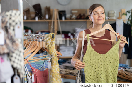 Adult woman choosing top in clothing store 136180369