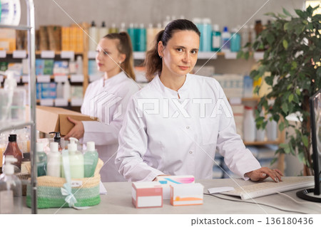 Female pharmacist working at computer in pharmacy 136180436