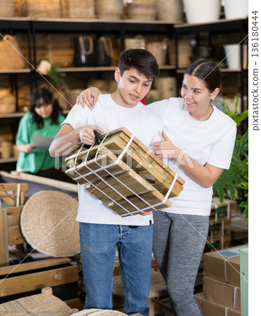 Young couple looking for folded wooden garden furniture in store Young couple looking for folded wooden garden furniture in store 136180444