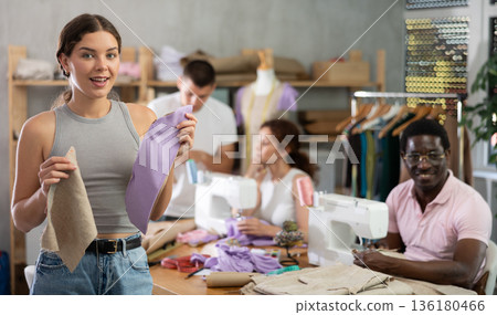 Young girl showing paper pattern in training sewing workshop 136180466