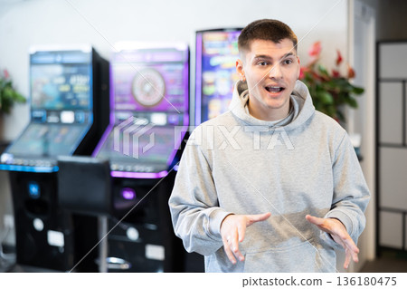 Guy standing in front of video game machines 136180475