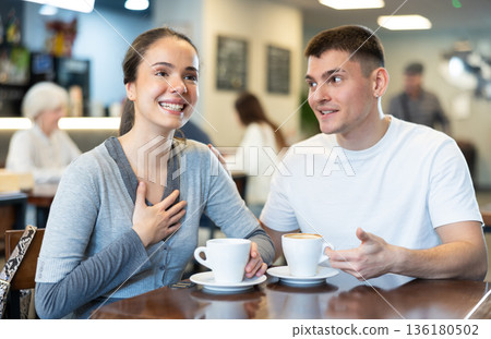 Couple man and woman drinking coffee and talking in cafe Couple man and woman drinking coffee and talking in cafe 136180502
