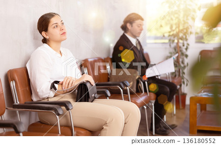 Young woman waiting for job interview in office corridor Young woman waiting for job interview in office corridor 136180552