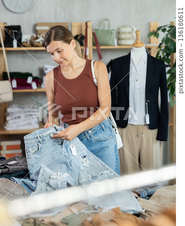 Adult woman choosing jeans in clothing store Adult woman choosing jeans in clothing store 136180611