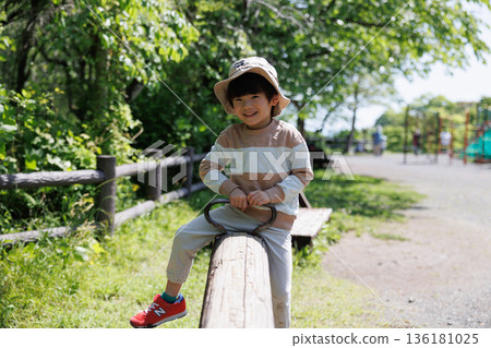 Boy playing with seesaw Boy playing with seesaw 136181025